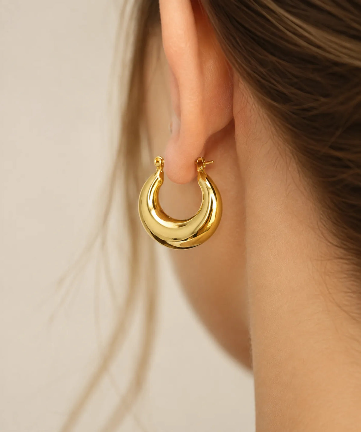 Model wearing the Gold Chunky Oval Hoop Earrings on the ear