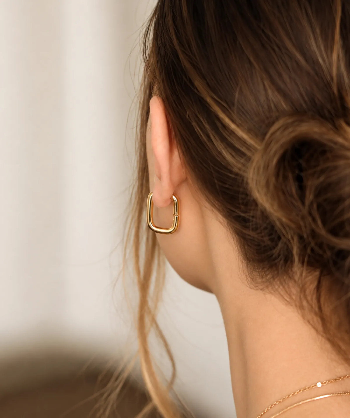 Model wearing the Gold Chunky Rectangular Hoop Earrings on the ear