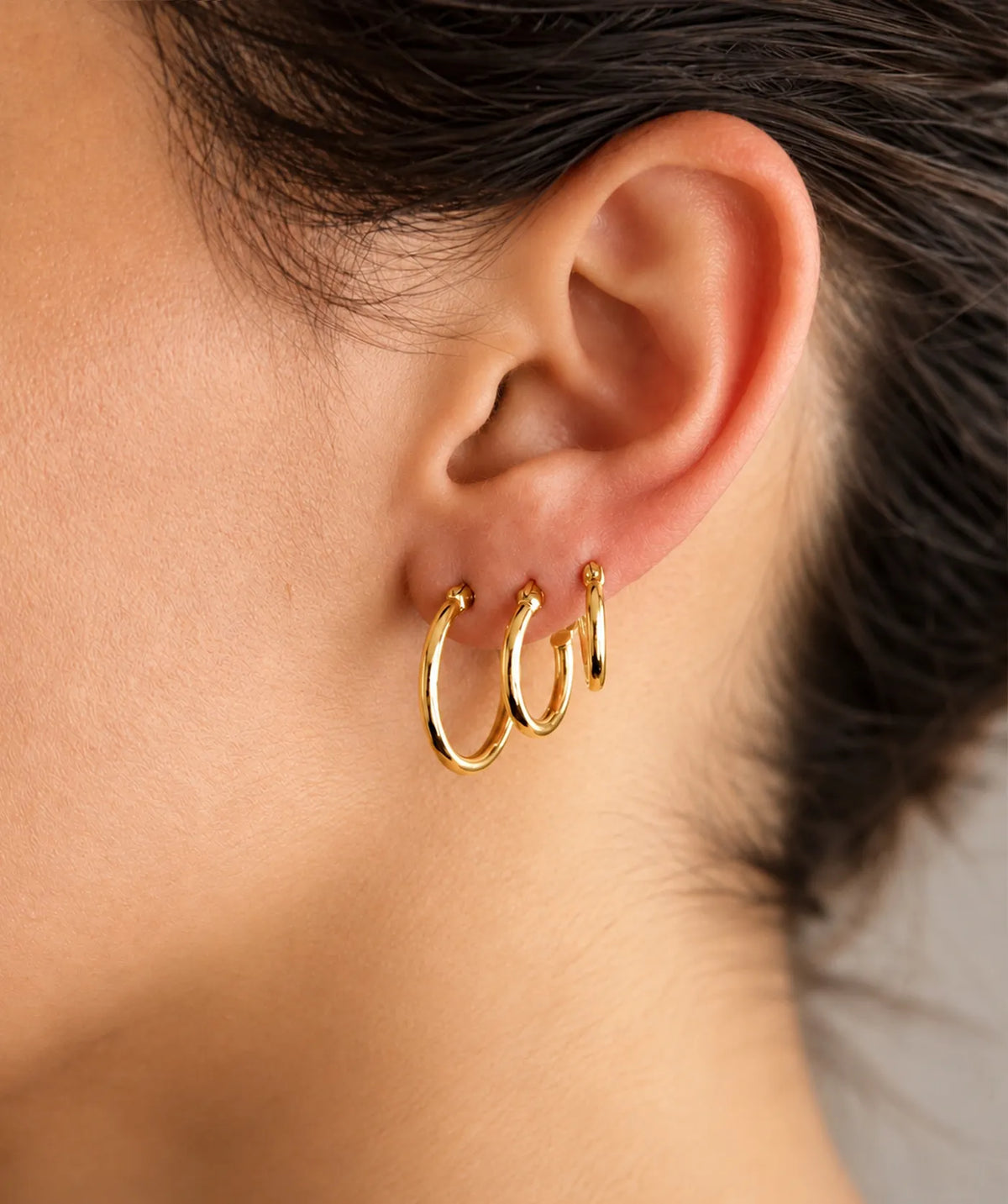 Model wearing the Gold Small Plain Hoop Earrings on the ear