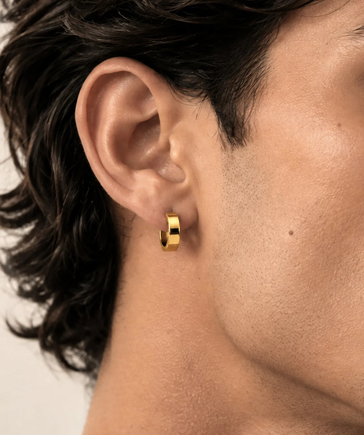 Model wearing the Gold Thick Round Flat Hoop Earrings on the ear