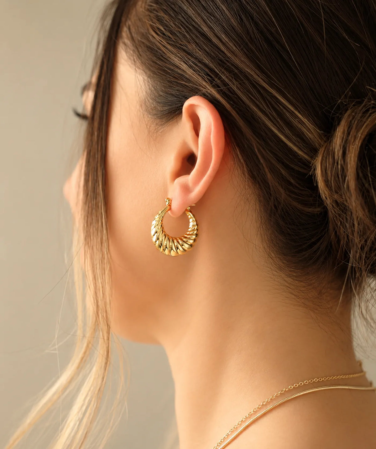 Model wearing the Gold Chunky Oval Croissant Hoop Earrings on the ear