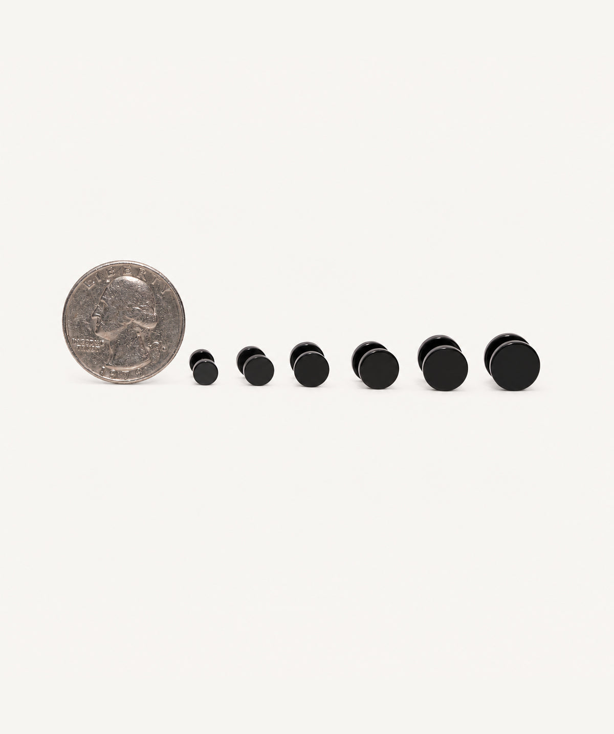 Black Screw Back Stud Earrings next to a coin for size reference